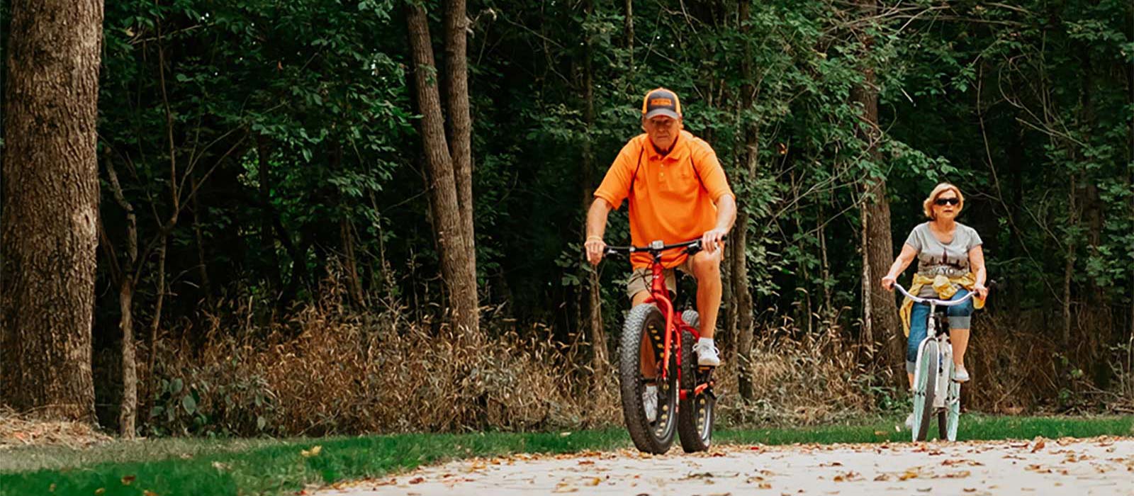 two people riding bicycles on the trail